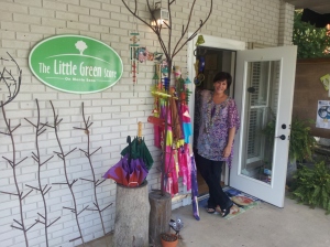 Ana Byrne, Ph.D., owner of The Little Green Store, peeks out on a recent Saturday.